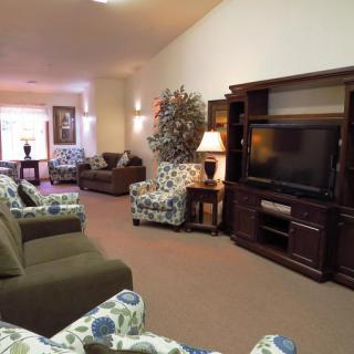 A spacious living room with cozy seating and an entertainment center.