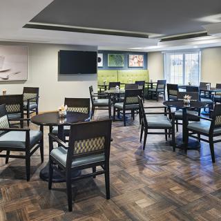 An empty indoor restaurant dining area with neatly arranged tables and chairs.