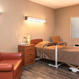 A hospital room with a bed, bedside table, and medical equipment.