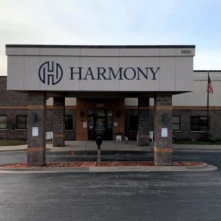 Front view of a commercial building with the logo and name 'Harmony' displayed above the entrance.