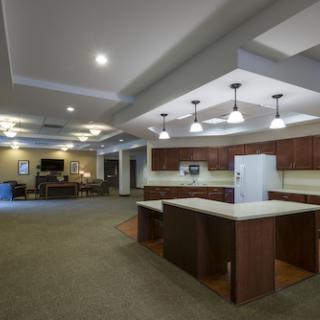 A spacious and modern kitchen area featuring an open layout with wooden cabinetry and contemporary lighting.