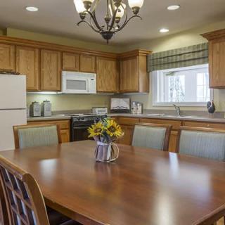 A cozy kitchen with wooden cabinets, a dining table, and modern appliances.