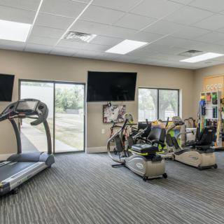 A modern gym interior featuring a treadmill and various exercise machines.