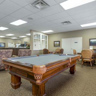 A spacious recreation room featuring a pool table and comfortable seating.