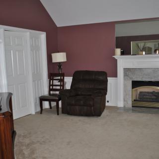 A cozy living room with an armchair and fireplace.