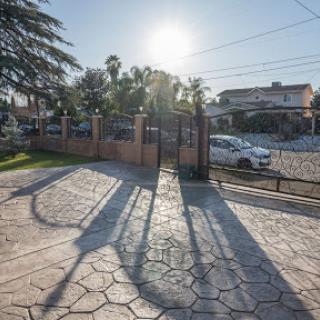 A serene view of a sunny day showcasing the shadows cast by a gate in a residential area.
