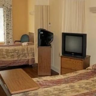 A hotel room with two beds and a vintage television set.