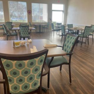 An empty dining room with neatly arranged tables and chairs.