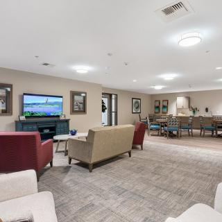 A modern living room featuring comfortable seating and a large television.