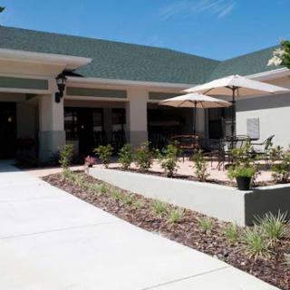 A welcoming entrance to a modern building with a landscaped patio area.