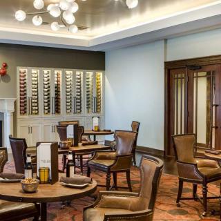 An elegant restaurant dining room with a wine display and cozy seating arrangement.