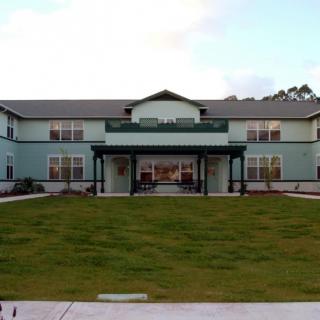 A two-story residential building with a well-kept lawn in front.