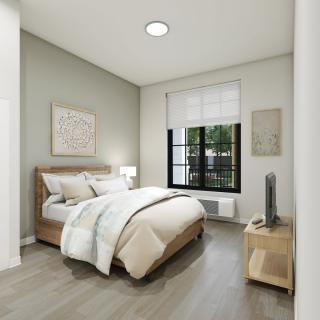 A modern, minimalist bedroom with neutral tones and cozy furnishings.