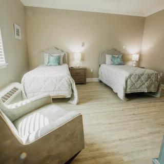 A cozy and modern bedroom featuring twin beds with neutral-colored bedding and contemporary furnishings.