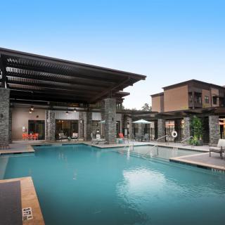 A modern residential property featuring a luxurious outdoor pool and patio area.