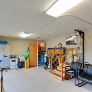 A well-organized garage space featuring storage solutions, exercise equipment, and seating.