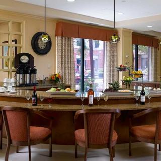 A cozy kitchen and dining area with a counter, seating, and warm lighting.