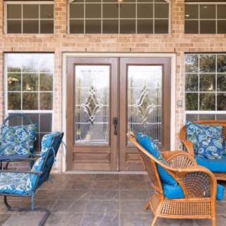 A cozy patio with blue-cushioned outdoor furniture and glass double doors.