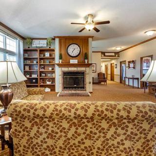 A cozy living room with a central fireplace, bookshelves, and comfortable seating.