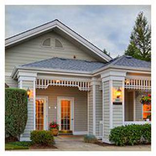 A well-lit, inviting house entrance with a porch and decorative columns.