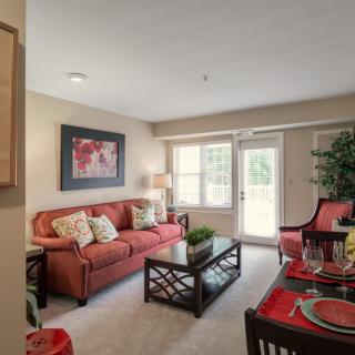 A cozy living room featuring a red sofa, coffee table, and decorative elements.