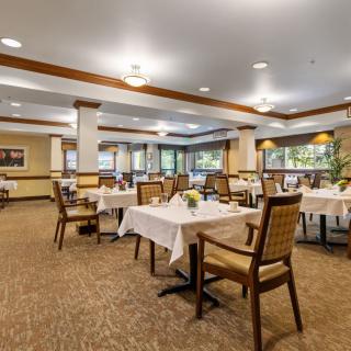 A spacious and well-lit dining area with neatly arranged tables and chairs.