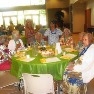 A group of elderly people enjoying a social gathering around a dining table.
