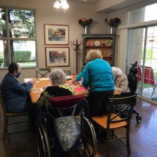 A group of elderly individuals engaging in an activity in a nursing home setting.