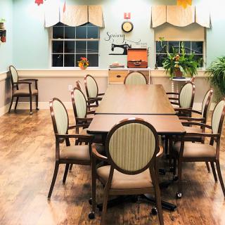 A decorated meeting room with a large table, surrounded by chairs and adorned with colorful decorations.