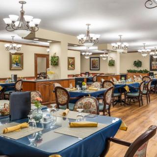 An elegant dining area with neatly arranged tables and chandeliers.