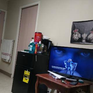 A view of a room featuring a television, refrigerator, and wall decor.