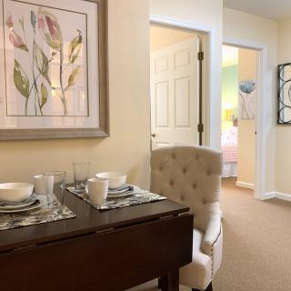 A cozy dining area with elegant table settings and wall art.
