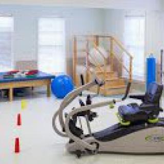 A well-equipped physical therapy room with exercise equipment and tools.