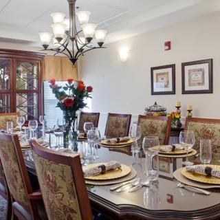 A beautifully set dining room table with elegant decor and a chandelier overhead.