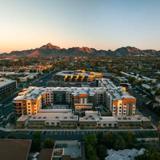 A stunning aerial view of modern residential buildings surrounded by mountains at sunset.
