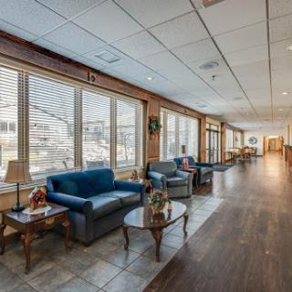 A cozy lounge area featuring blue sofas and ample natural light from large windows.