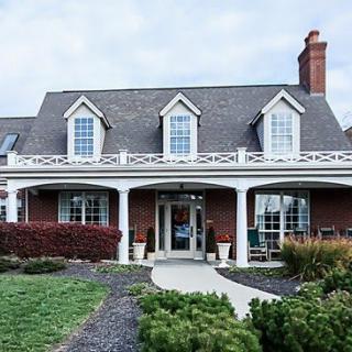 A charming house with a wide porch and manicured landscaping.