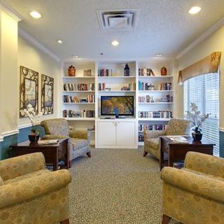 A cozy living room with bookshelves and comfortable armchairs.