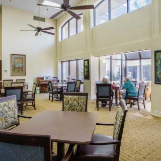 A spacious, well-lit dining area with modern furnishings and large windows.