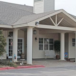 Front entrance of a residential building with a covered porch and columns.