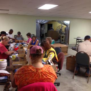 A group of individuals engaging in a collaborative crafting session in a community space.