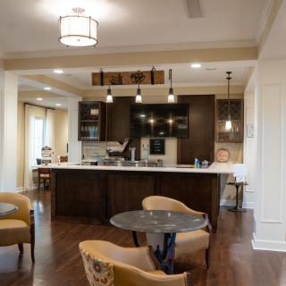 A modern kitchen with an open layout, featuring a central island and stylish lighting.