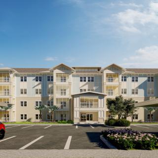 A modern apartment building with a spacious parking lot and landscaped surroundings on a clear day.
