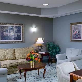 A cozy living room with sofas, chairs, a coffee table, and artwork on the walls.