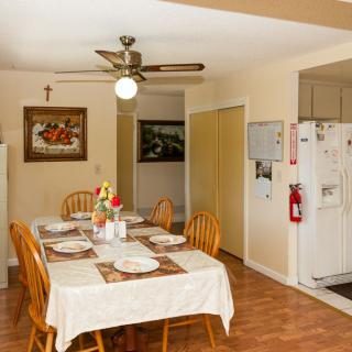 A cozy dining area with a set table and chairs, adjacent to the kitchen.