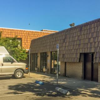 A van parked in front of a brick building on a clear day.