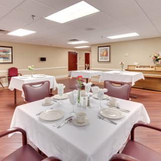 A well-arranged dining area in a care facility, featuring elegantly set tables and a welcoming atmosphere.