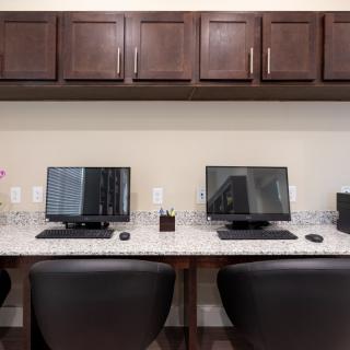 A well-organized office space with multiple computer workstations and dark wooden cabinets.