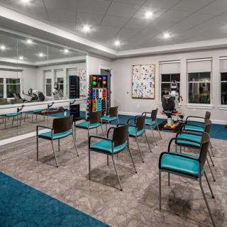 A modern conference room with teal chairs and contemporary artwork.