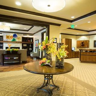 A modern lobby with elegant decor and a central table adorned with flowers.